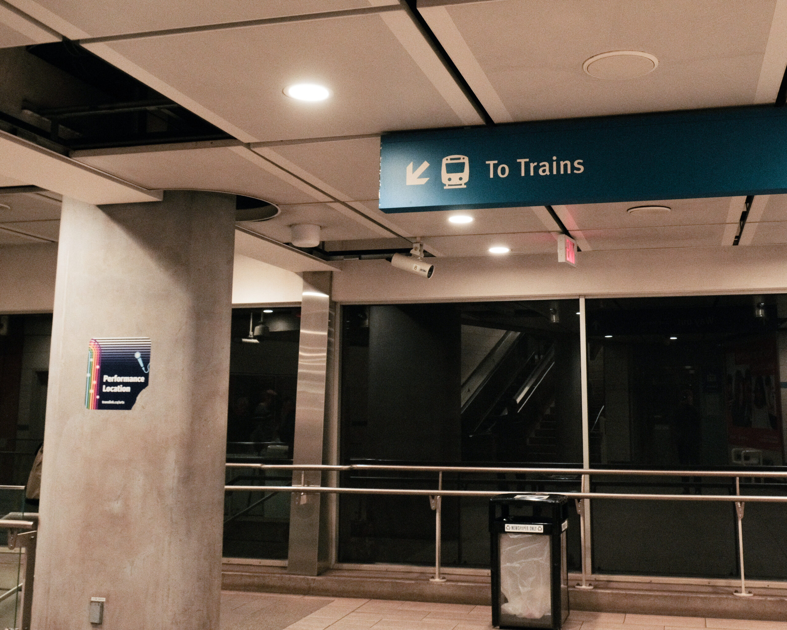 Signage before escalator to platform it only says 'To Trains'